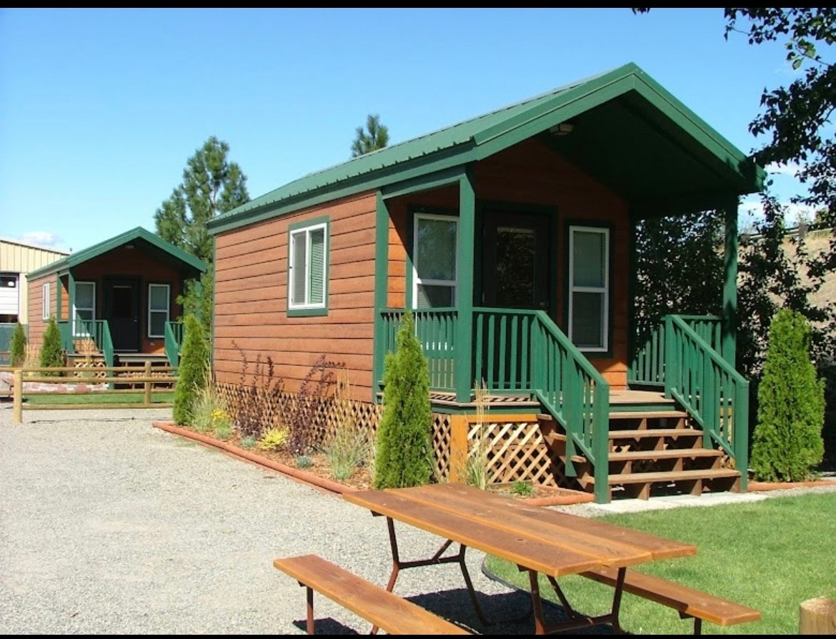 Deluxe cabin with green trim and picnic table